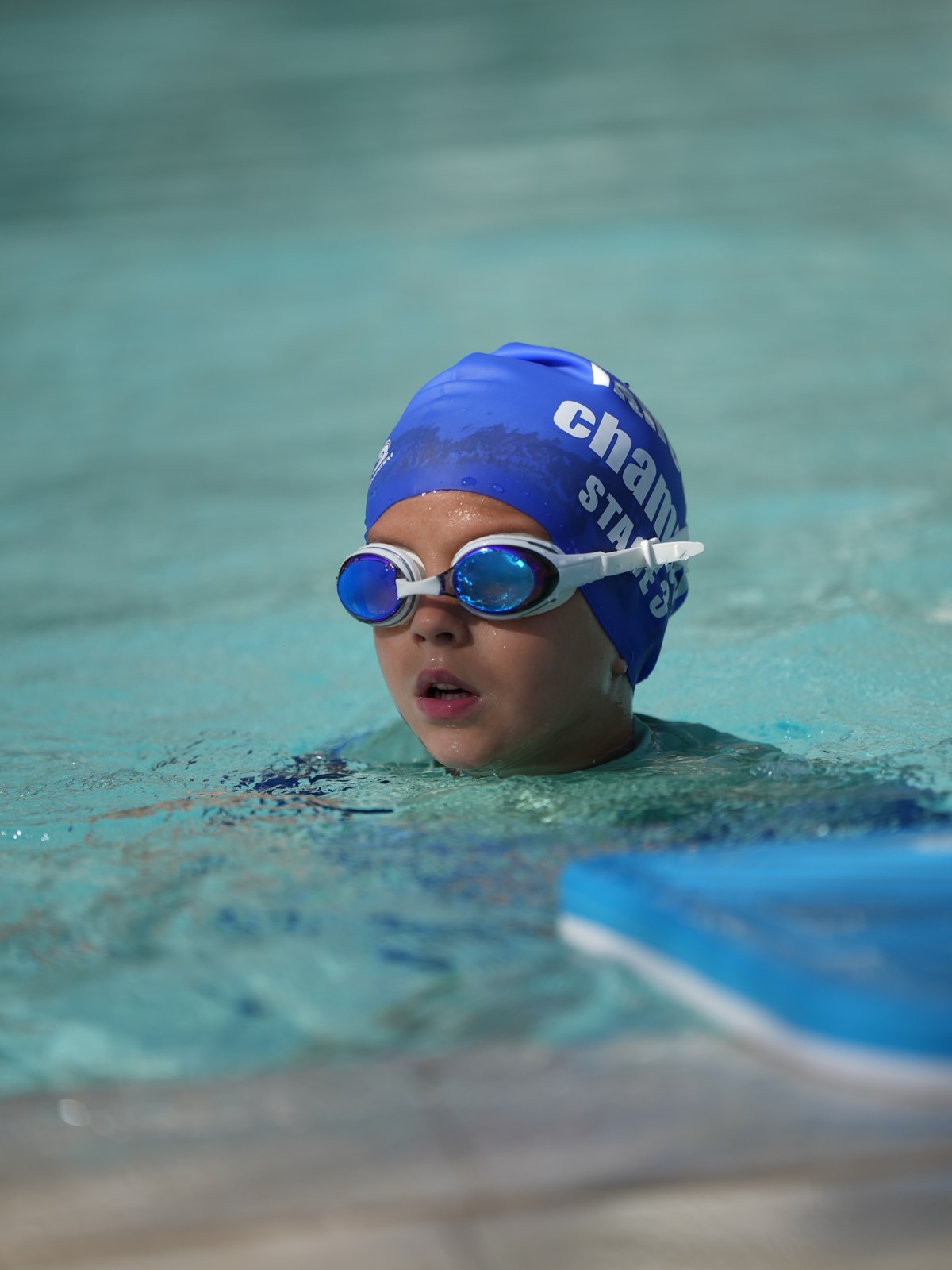 A Fitness Champs coach celebrating with a young swimmer during a lesson in Dubai